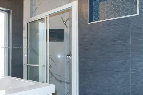 a bathroom with a granite countertop sink a large mirror and a shower
