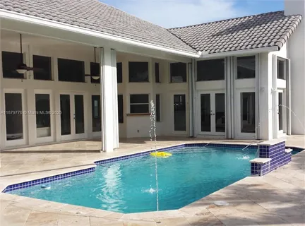 a view of a house with pool and sitting area