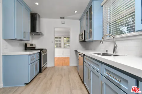 a kitchen with stainless steel appliances granite countertop a sink and wooden cabinets