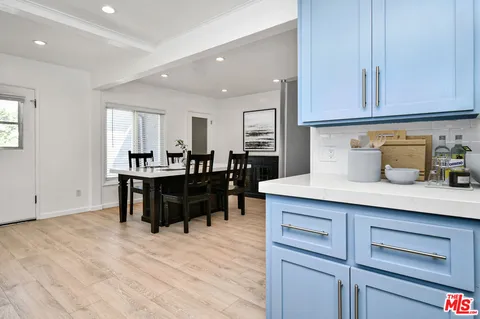 a kitchen with a stove a refrigerator and a dining table