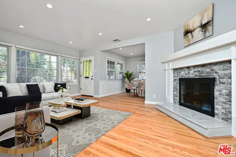a living room with furniture a fireplace and a floor to ceiling window