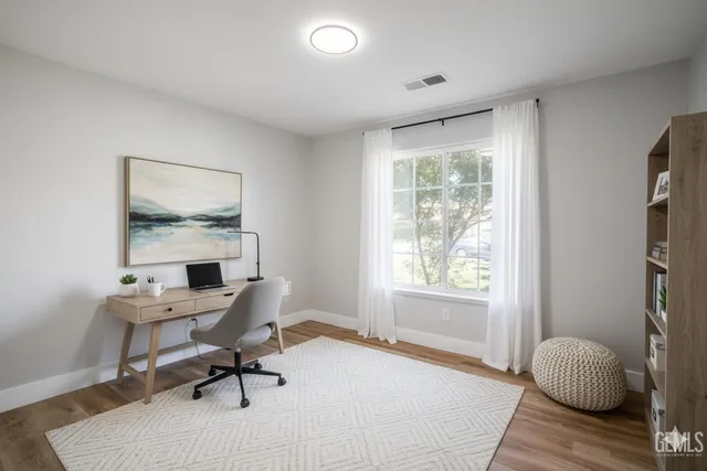 a workspace with wooden floor and a window