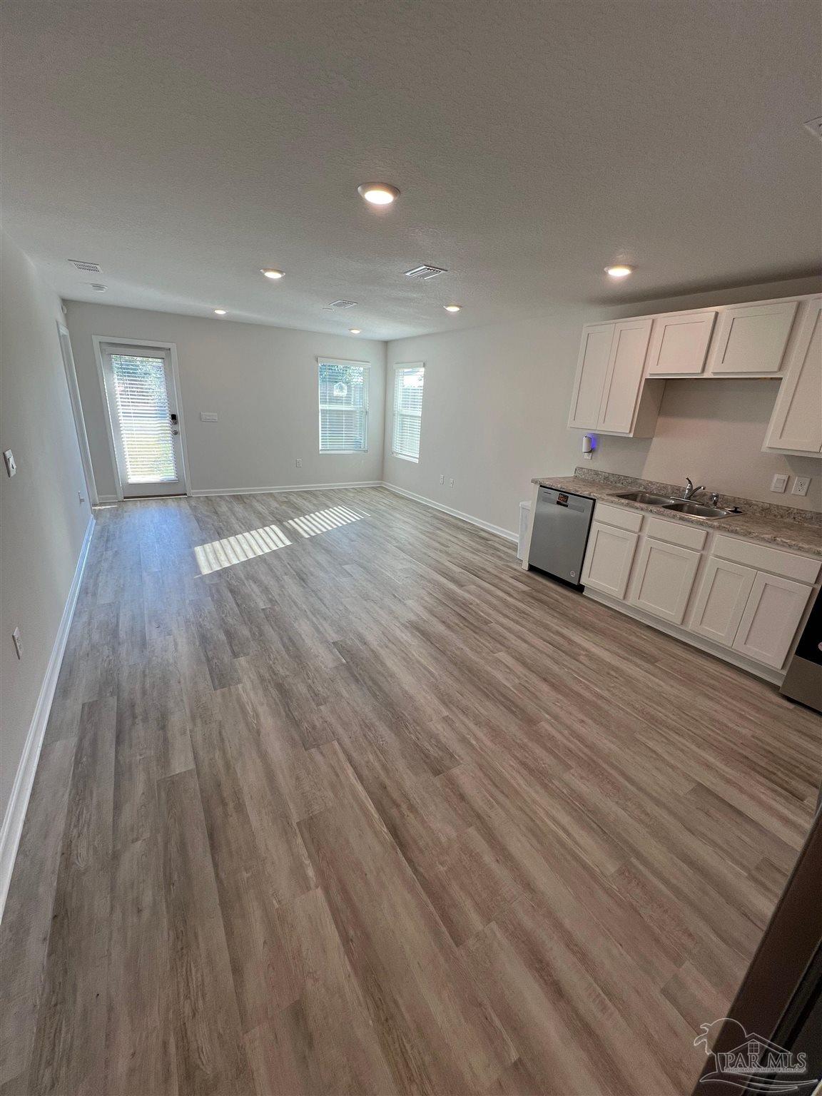 6235 June Bug Drive Milton, FL 32583 - Photo 6 of 20 a view of an empty room with wooden floor and kitchen