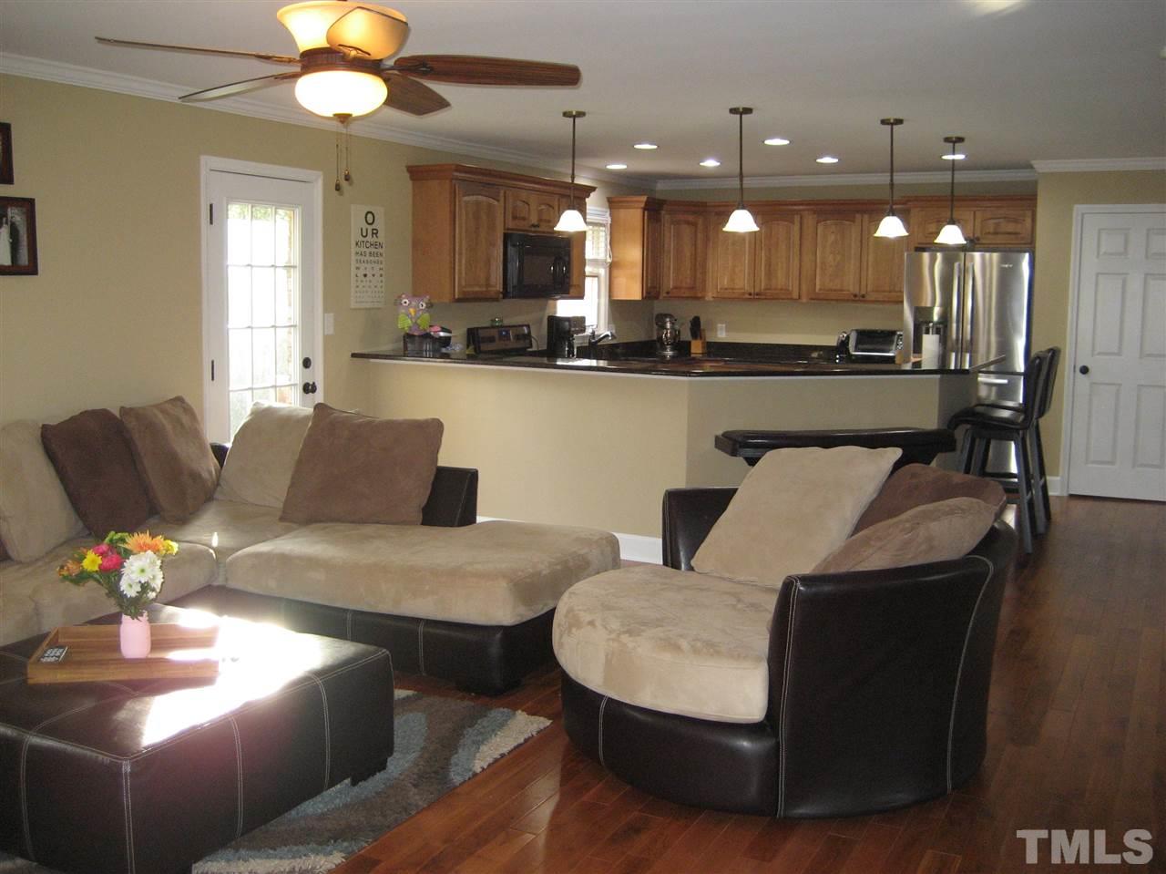 9740 South Lowell Road Bahama, NC 27503 - Photo 14 of 17 a living room with couches and kitchen view with wooden floor
