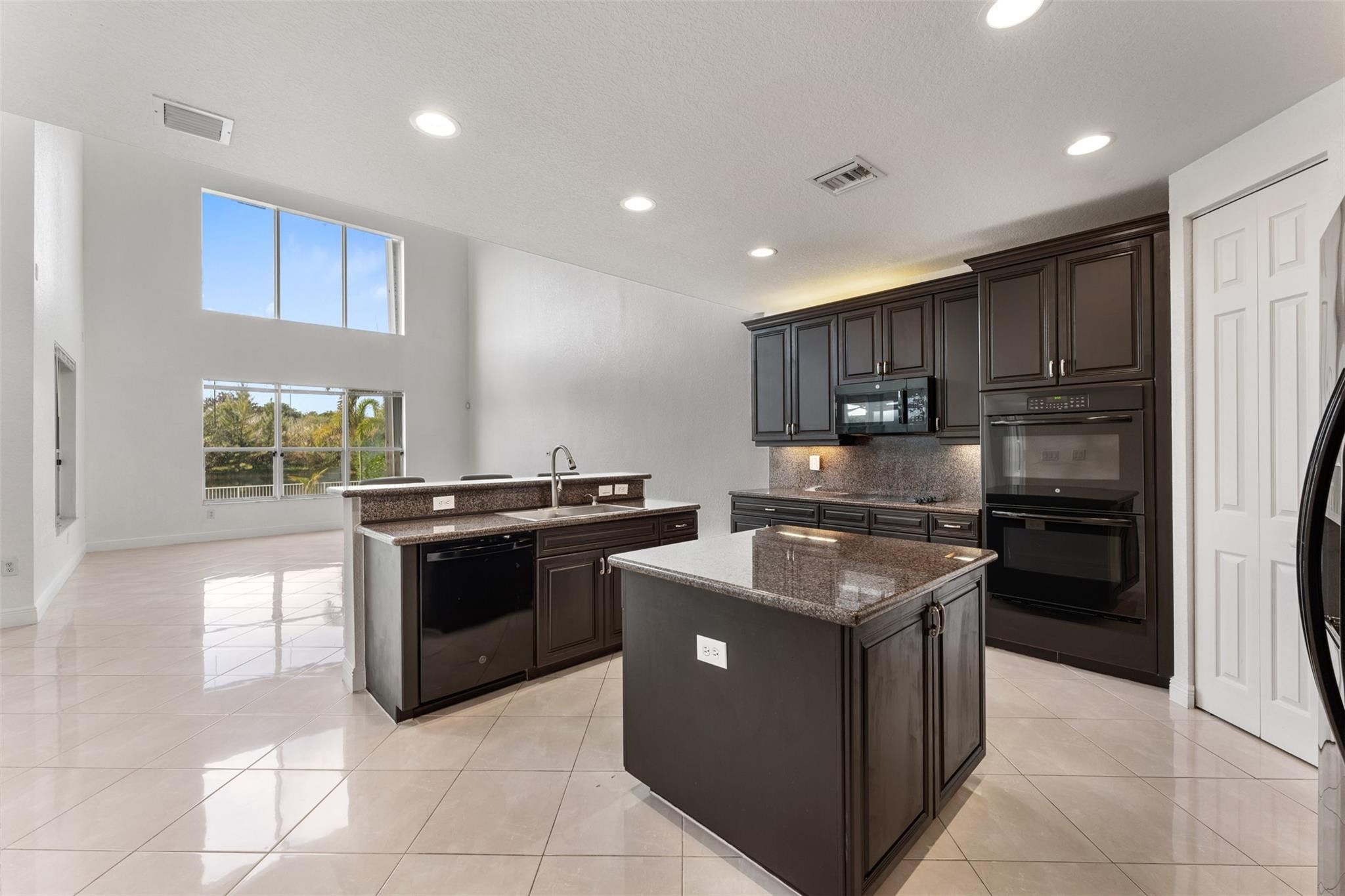 5318 Southwest 195th Terrace Miramar, FL 33029 - Photo 17 of 67 a kitchen with kitchen island granite countertop wooden cabinets and stainless steel appliances