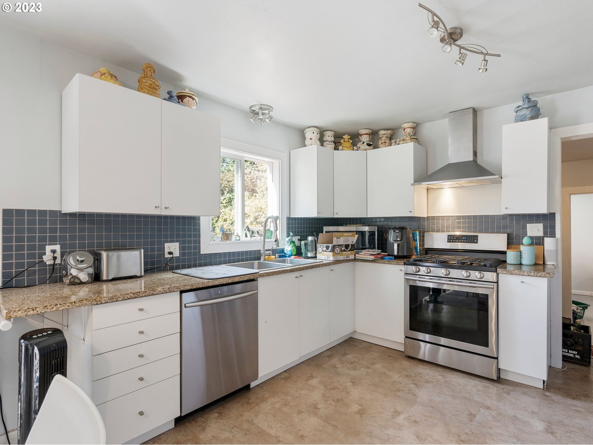 17680 Southwest Alexander Street Beaverton, OR 97003 - Photo 15 of 38 a kitchen with white cabinets stainless steel appliances and sink