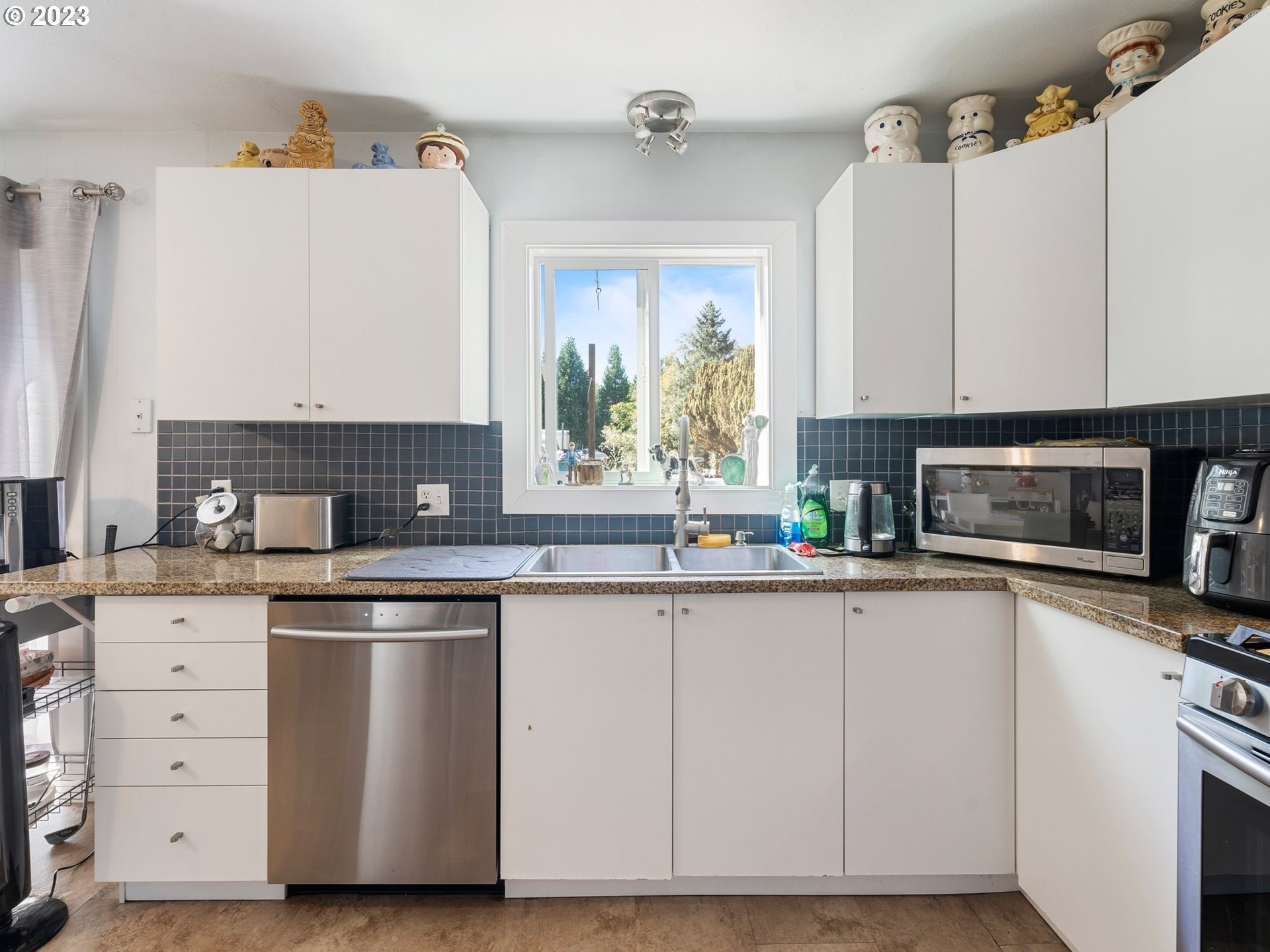 17680 Southwest Alexander Street Beaverton, OR 97003 - Photo 16 of 38 a kitchen with cabinets appliances a sink and a window