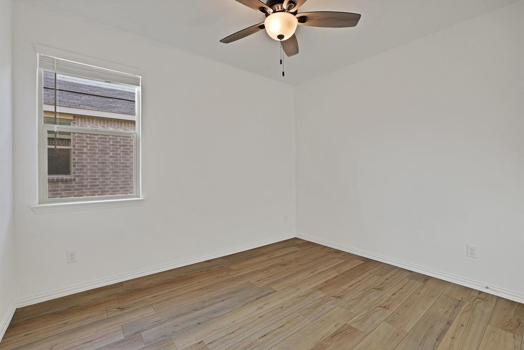 3204 Renaissance Drive Denton, TX 76207 - Photo 15 of 25 Light-filled interior space featuring wood-finish flooring, white baseboards, and a ceiling fan with integrated lighting