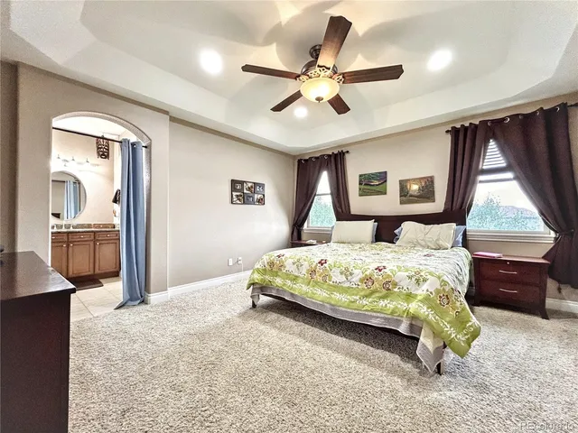 a bedroom with a large bed and a chandelier