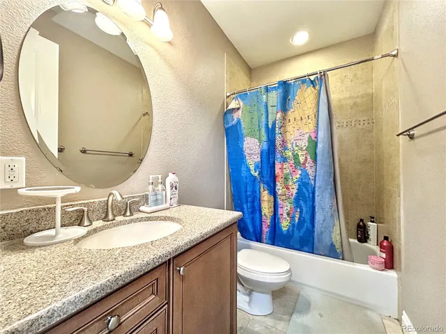 a bathroom with a granite countertop sink toilet and shower