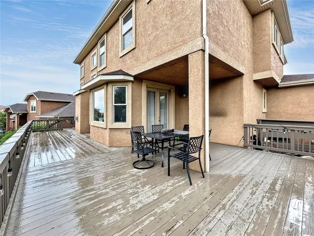 a view of a patio with table and chairs with wooden floor and fence