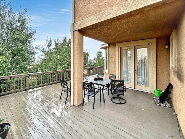 a view of a house with wooden deck and furniture