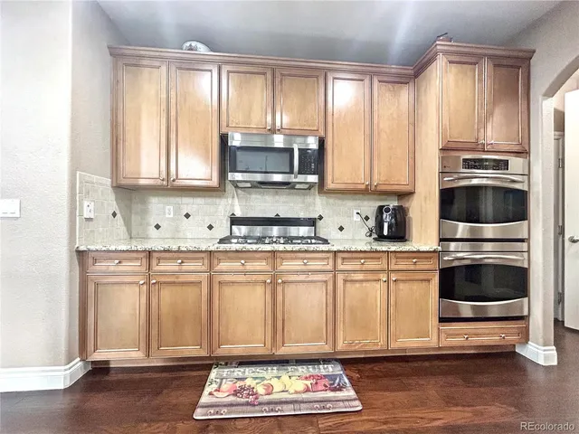 a kitchen with stainless steel appliances granite countertop a stove a sink and a microwave