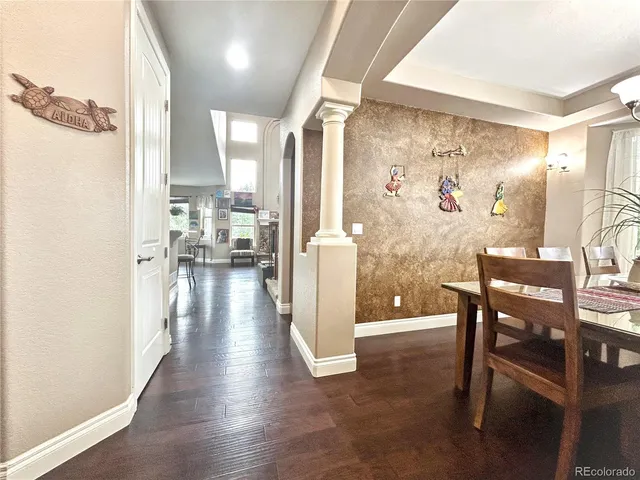 a view of a hallway with wooden floor windows and a chandelier