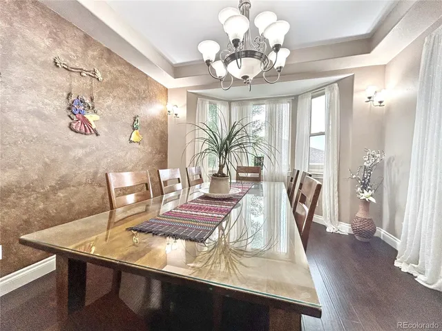 a view of a dining room with furniture a chandelier and wooden floor
