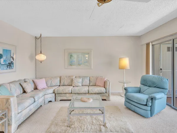 a living room with furniture and a floor to ceiling window