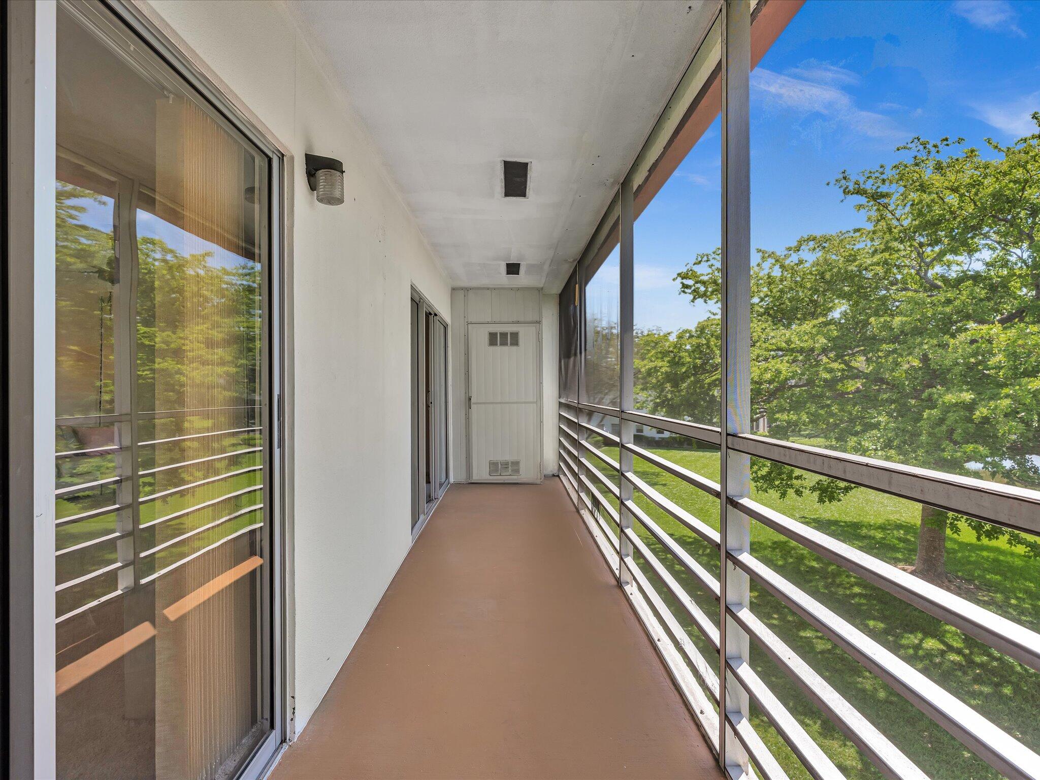 288 Fanshaw Drive, Unit G Boca Raton, FL 33434 - Photo 19 of 49 a view of a balcony with floor to ceiling windows with wooden floor