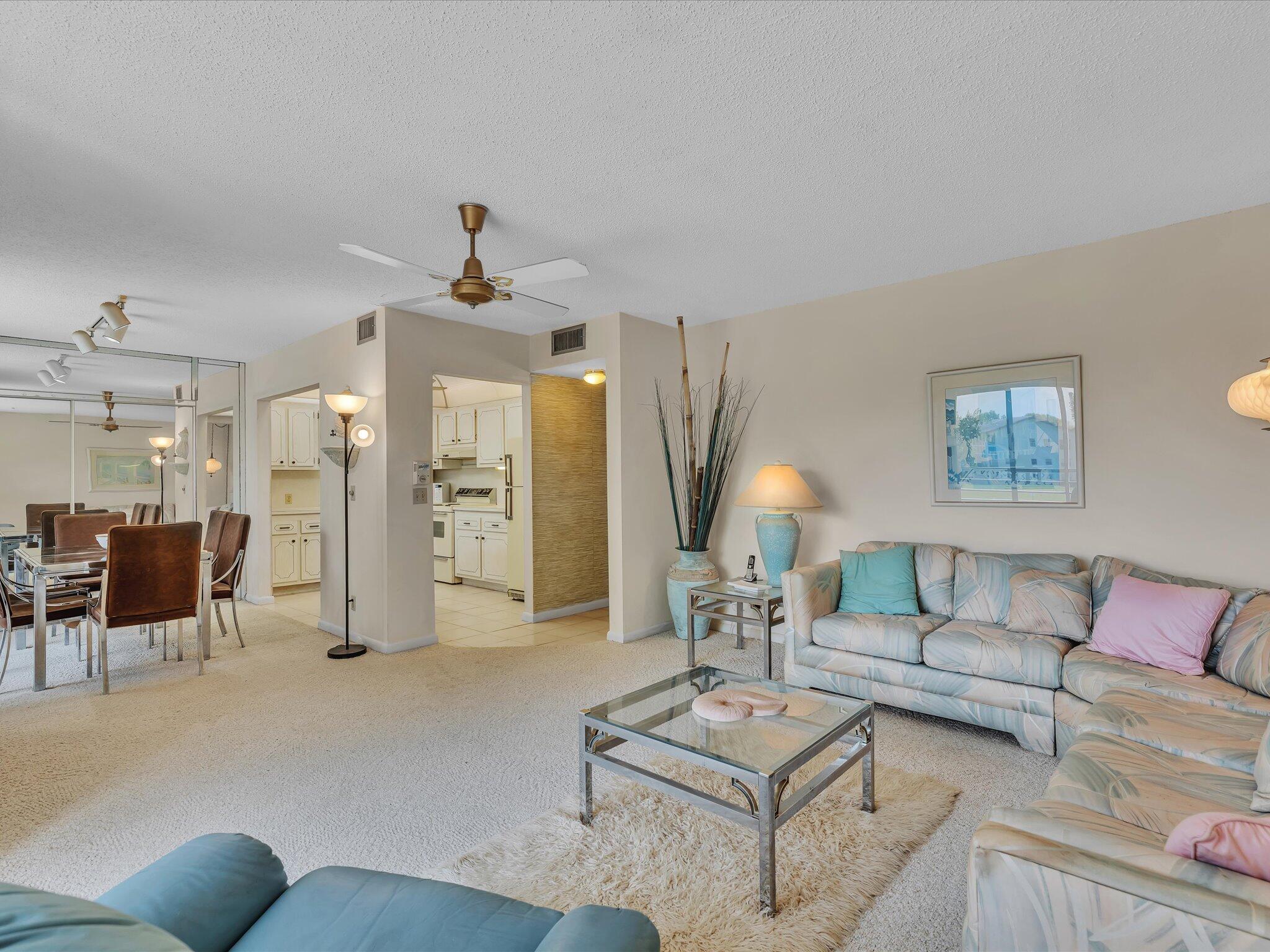 288 Fanshaw Drive, Unit G Boca Raton, FL 33434 - Photo 22 of 49 a living room with furniture a lamp and a chandelier