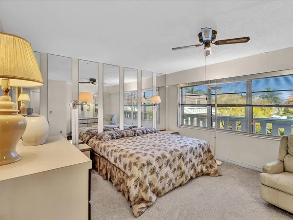 a bedroom with a bed and a large window
