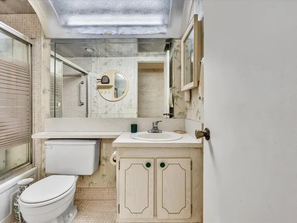 a bathroom with a sink a toilet and a mirror