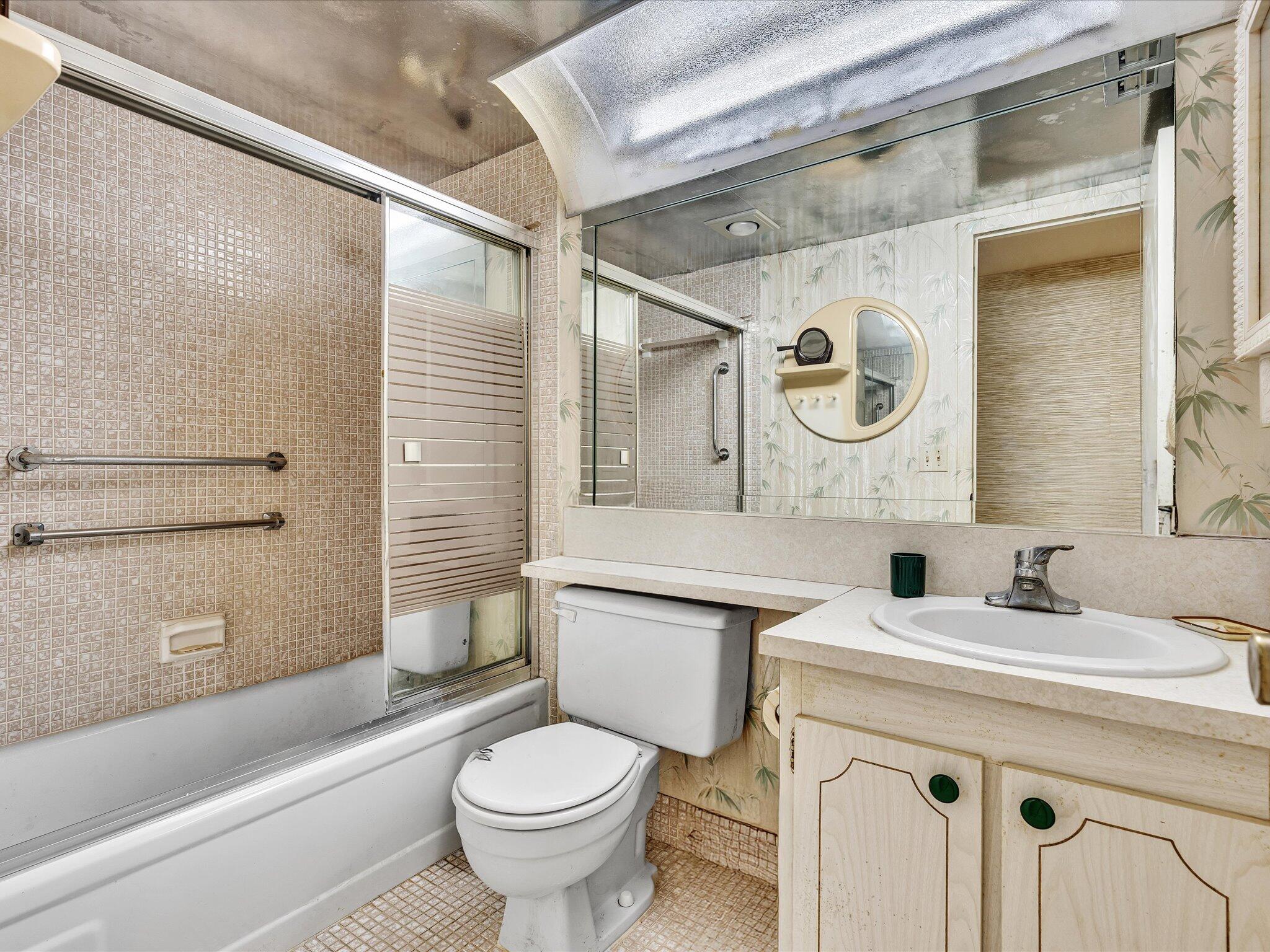 288 Fanshaw Drive, Unit G Boca Raton, FL 33434 - Photo 27 of 49 a bathroom with a sink a toilet and a mirror