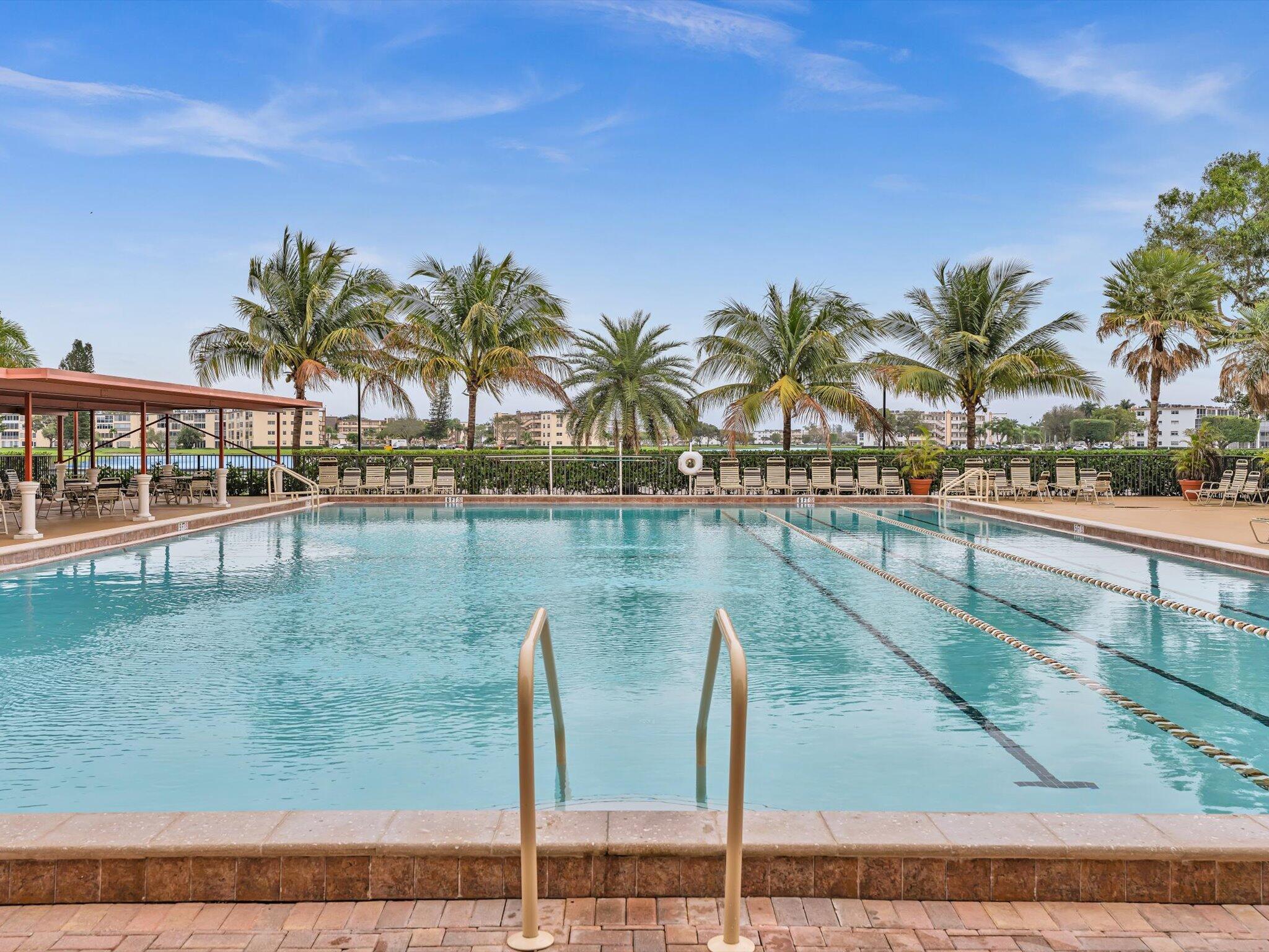 288 Fanshaw Drive, Unit G Boca Raton, FL 33434 - Photo 43 of 49 a view of a swimming pool with a table and chairs