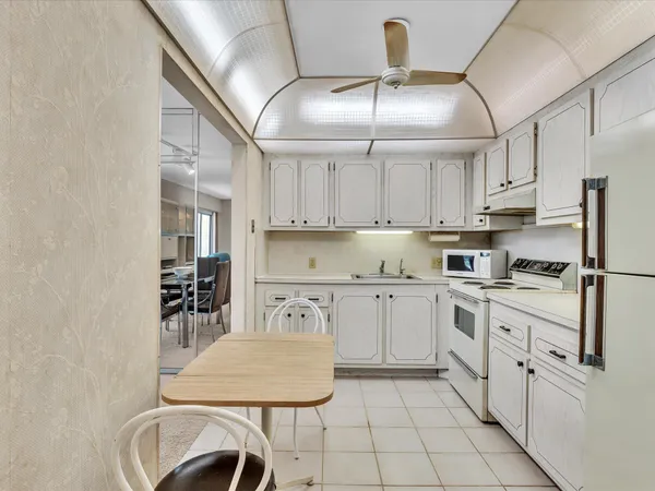 a kitchen with white cabinets and white appliances