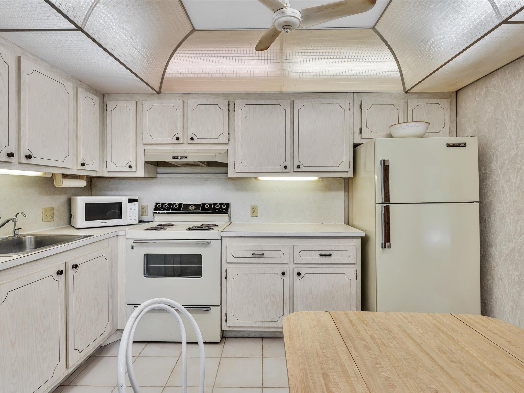 288 Fanshaw Drive, Unit G Boca Raton, FL 33434 - Photo 10 of 49 a kitchen with cabinets and white appliances