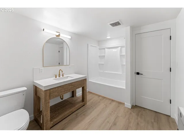 a bathroom with a sink mirror vanity and toilet