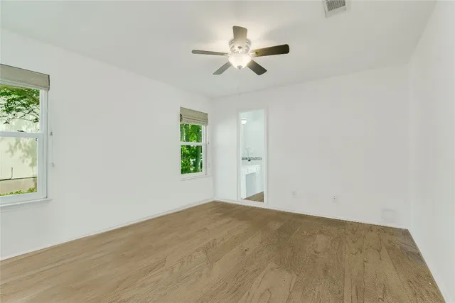 a view of a big room with wooden floor and windows