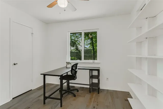 a view of a workspace with furniture and a window