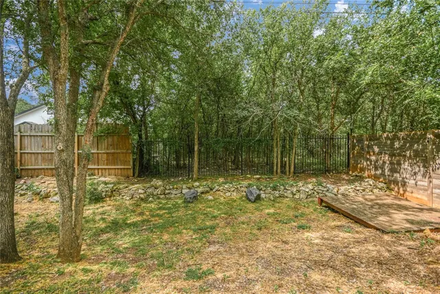 a view of a yard with plants and trees