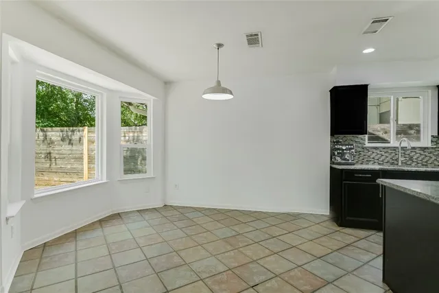 a view of an empty room with window and cabinet