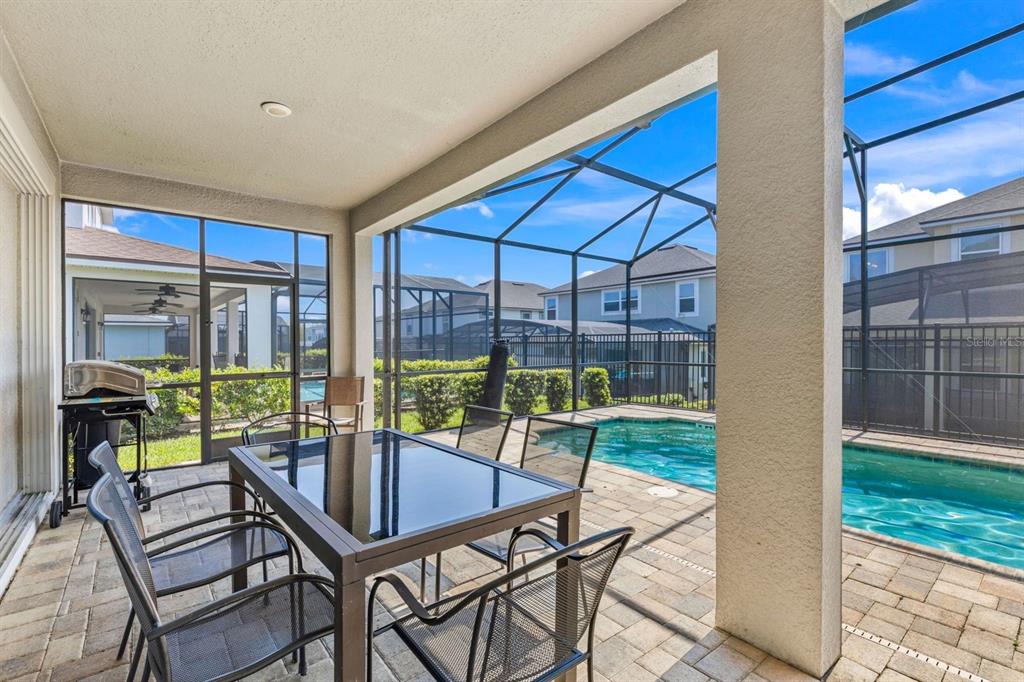 9042 Sunshine Ridge Loop Kissimmee, FL 34747 - Photo 16 of 44 a view of a patio with a dining table and chairs