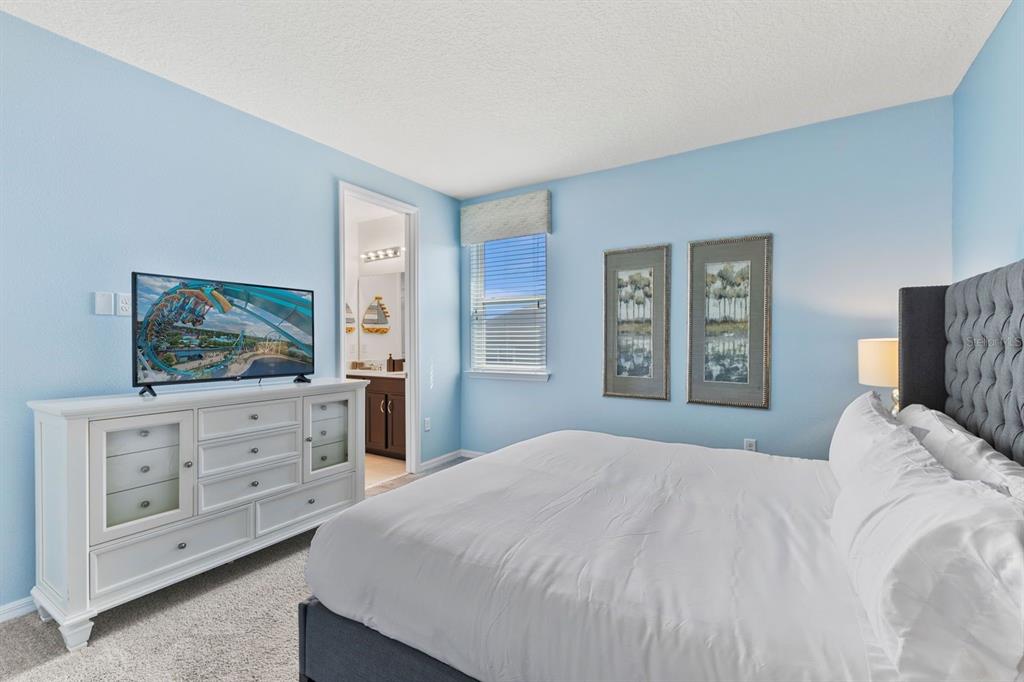 9042 Sunshine Ridge Loop Kissimmee, FL 34747 - Photo 20 of 44 a bedroom with a bed and a flat screen tv