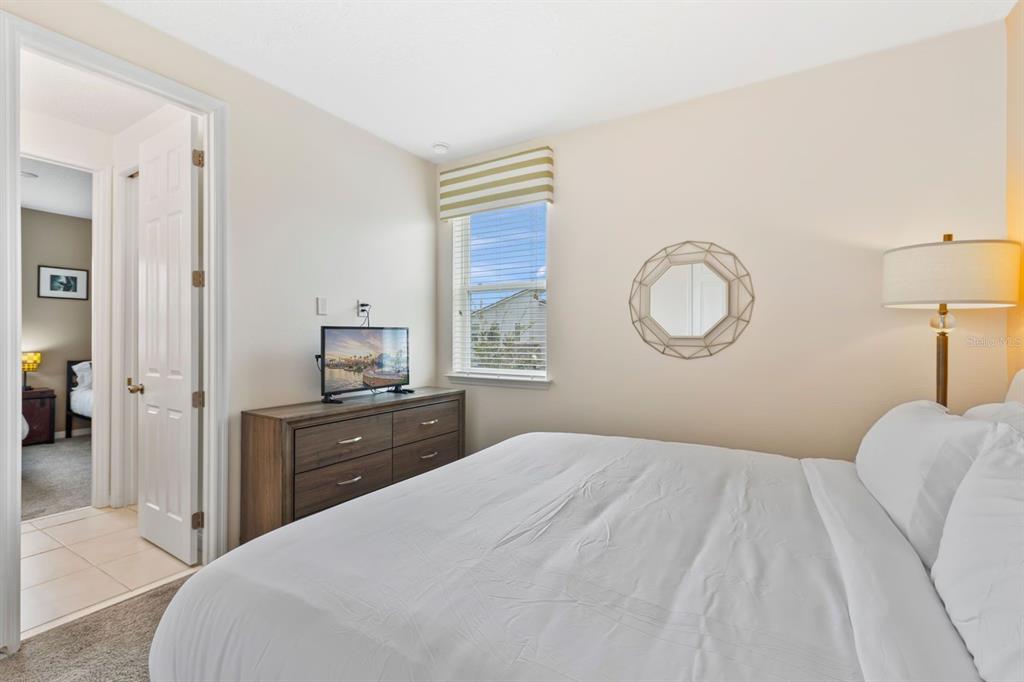 9042 Sunshine Ridge Loop Kissimmee, FL 34747 - Photo 22 of 44 a bedroom with a bed and a lamp