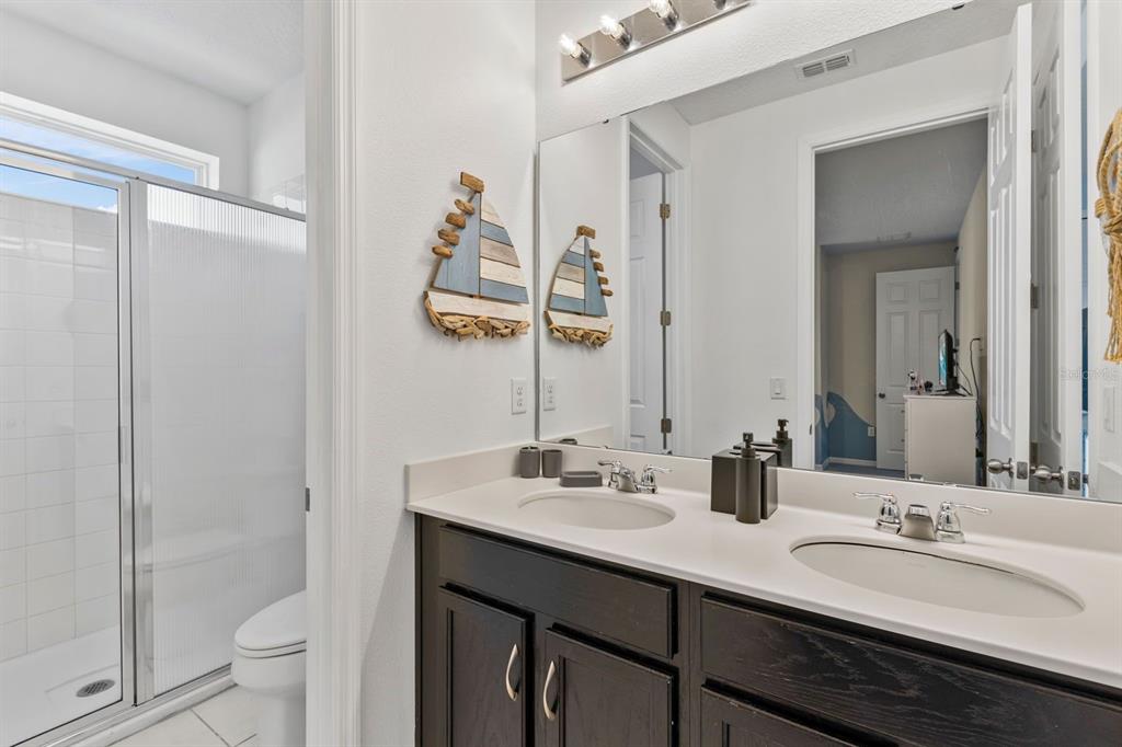 9042 Sunshine Ridge Loop Kissimmee, FL 34747 - Photo 26 of 44 a bathroom with a double vanity sink toilet and shower