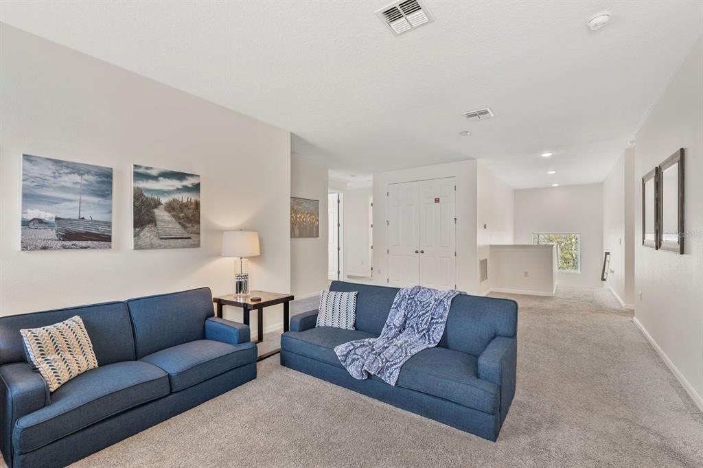9042 Sunshine Ridge Loop Kissimmee, FL 34747 - Photo 37 of 44 a living room with furniture white walls and a couch