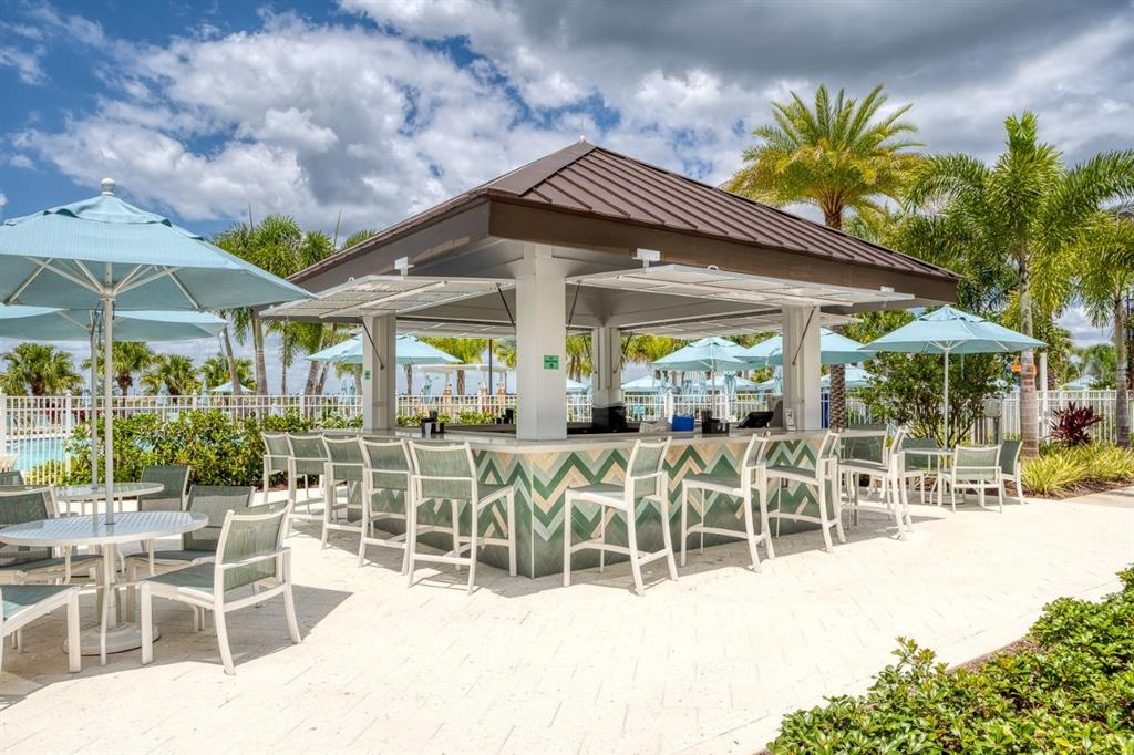 9042 Sunshine Ridge Loop Kissimmee, FL 34747 - Photo 42 of 44 a patio with a table and chairs under an umbrella