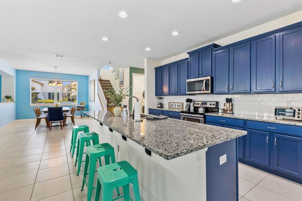 9042 Sunshine Ridge Loop Kissimmee, FL 34747 - Photo 5 of 44 a kitchen with sink cabinets and dining table