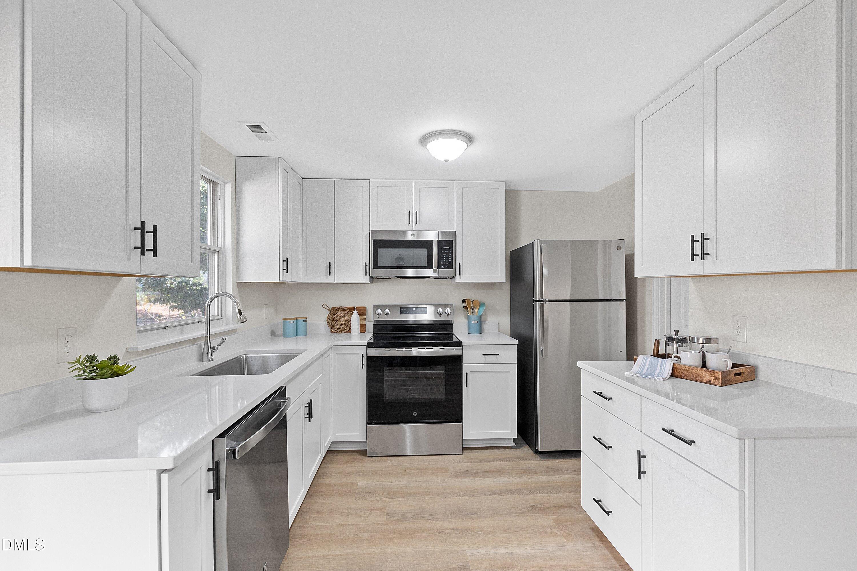 632 Middleton Avenue Cary, NC 27513 - Photo 15 of 34 a kitchen with white cabinets and stainless steel appliances