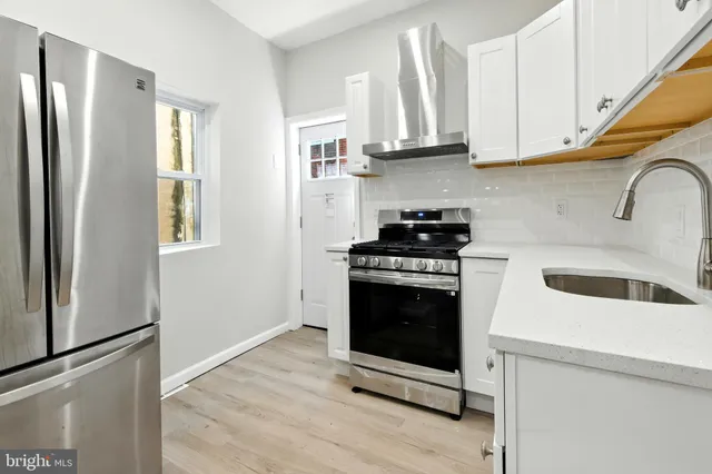 a kitchen with stainless steel appliances granite countertop a stove a refrigerator and a sink