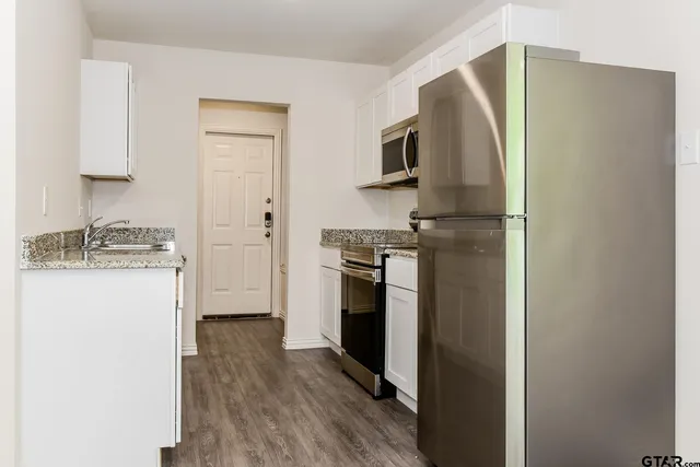 a kitchen with a refrigerator and a stove top oven