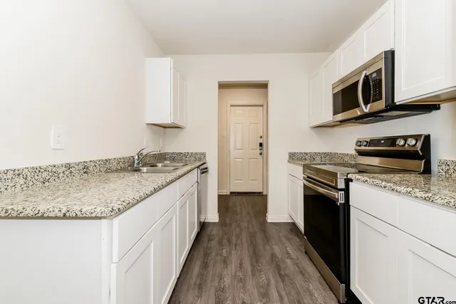 a kitchen with stainless steel appliances granite countertop a sink stove and refrigerator