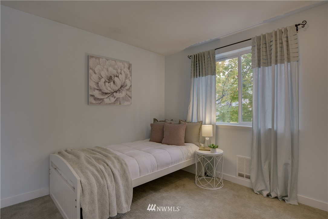 9200 Greenwood Avenue North, Unit 104 Seattle, WA 98103 - Photo 14 of 19 a bedroom with a bed and a window