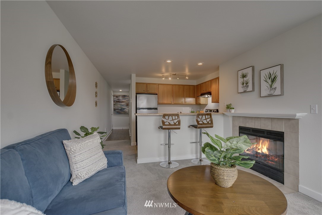9200 Greenwood Avenue North, Unit 104 Seattle, WA 98103 - Photo 6 of 19 a living room with furniture potted plant and a fireplace