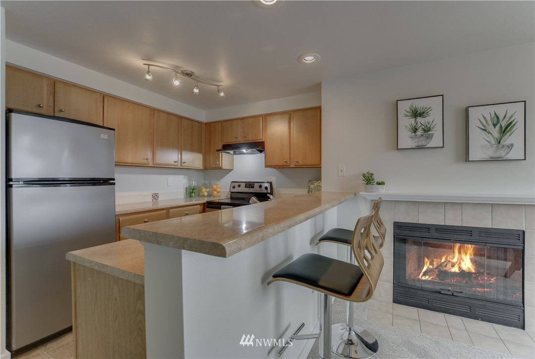 9200 Greenwood Avenue North, Unit 104 Seattle, WA 98103 - Photo 8 of 19 a kitchen with cabinets and a fireplace