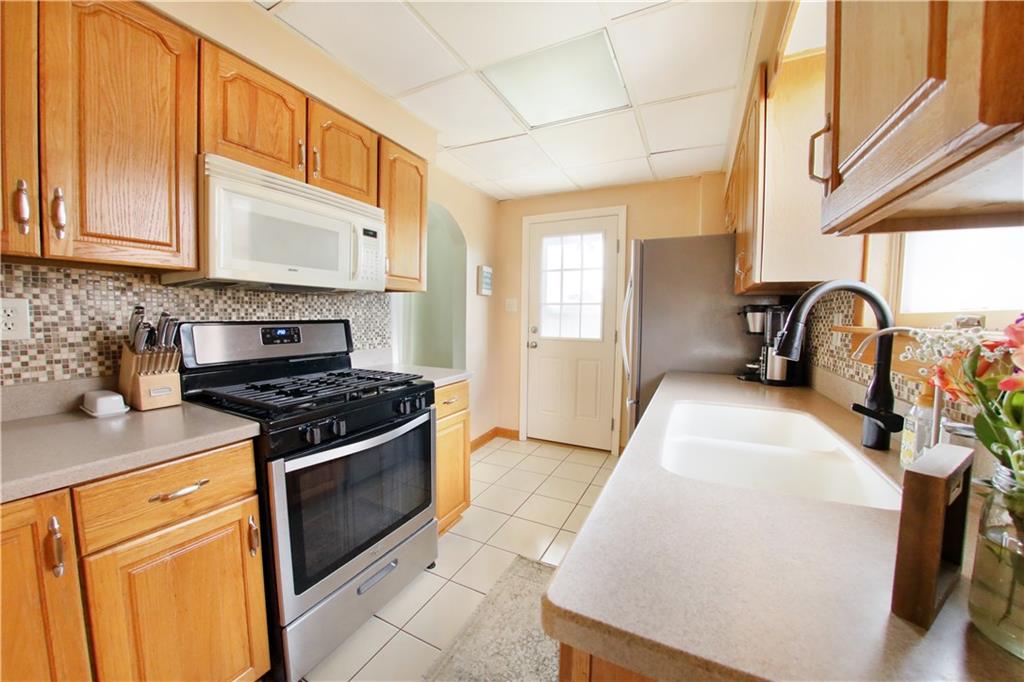 985 Ridge Road Bridgeville, PA 15017 - Photo 8 of 22 GREAT WORK SPACE FOR MEAL PREP. NEWER STAINLESS APPLIANCES, SOLID SURFACE COUNTERS SOLID WOOD CABINETS AND STYLISH BACKSPLASH.