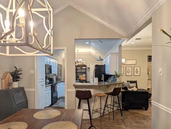 a living room with stainless steel appliances kitchen island granite countertop furniture and a view of kitchen