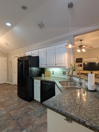 a kitchen with stainless steel appliances granite countertop a refrigerator and a sink
